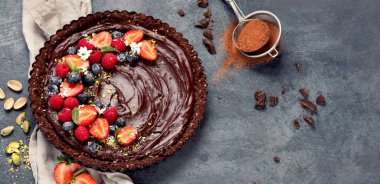 Gri arka planda lezzetli çikolatalı tart. Ev yapımı tatlı konsepti. Üst görünüm, düz görünüm, kopyalama alanı