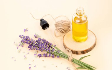 Hafif şeftali arka planında bir şişe gerekli yağ ve lavanta çiçeği.. 