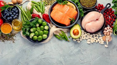 Açık gri arka planda sağlıklı yiyecek seçimi. Temiz yeme konsepti. Üst görünüm, düz görünüm, kopyalama alanı