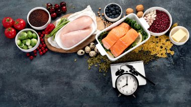 Sağlıklı beslenme planı. Koyu gri arka planda diyet ve yemek planlaması. Üst görünüm, düz görünüm, kopyalama alanı