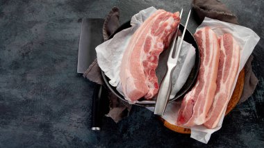 Koyu gri arka planda çiğ domuz göbeği. Organik gurme yemek konsepti. Üst görünüm, düz görünüm, kopyalama alanı