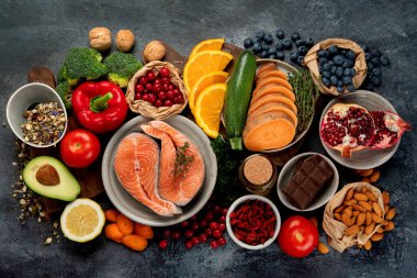 Koyu gri arka planda yaşlanma karşıtı menü. Yüksek miktarda antioksidan, mineral ve vitamin. Üst manzara, düz uzanma