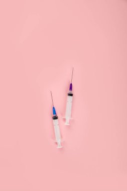 Şırıngalar pembe arka planda. Tıbbi konsept ve aşı. Üst görünüm, düz görünüm, kopyalama alanı
