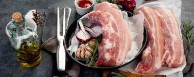 Koyu gri arka planda çiğ domuz göbeği. Organik gurme yemek konsepti. Panorama, bayrak