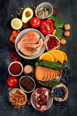 Koyu gri arka planda yaşlanma karşıtı menü. Yüksek miktarda antioksidan, mineral ve vitamin. Üst manzara, düz la