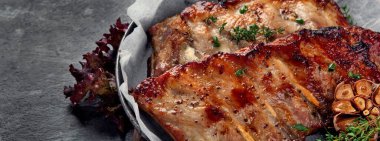 Koyu gri arka planda abur cubur ve sos ile kızarmış pirzola. Gurme yemek pişirme konsepti. 