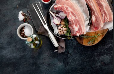 Koyu gri arka planda çiğ domuz göbeği. Organik gurme yemek konsepti. Üst görünüm, düz görünüm, kopyalama alanı