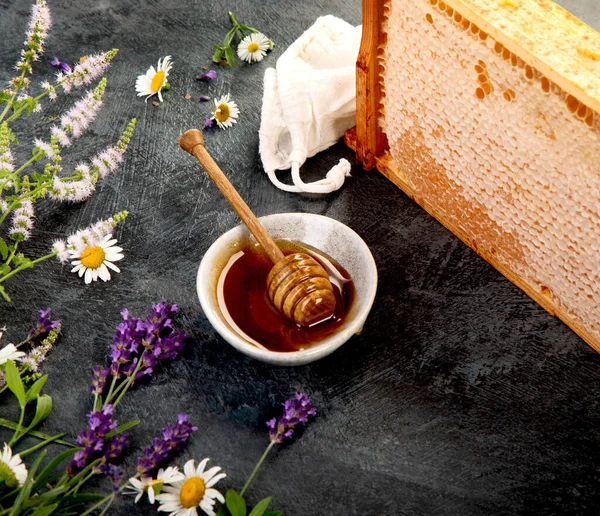 Kavanozda bal ve gri arka planda bal peteği. 