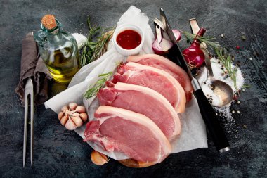 Koyu gri arka planda dilimlenmiş çiğ domuz eti. Organik gurme yemek konsepti. Üst manzara, düz uzanma