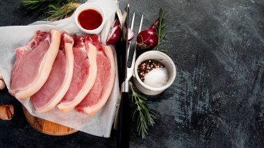 Koyu gri arka planda dilimlenmiş çiğ domuz eti. Organik gurme yemek konsepti. Üst görünüm, düz görünüm, kopyalama alanı
