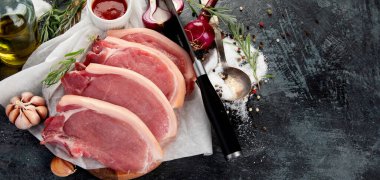 Koyu gri arka planda dilimlenmiş çiğ domuz eti. Organik gurme yemek konsepti. Boşluğu kopyala