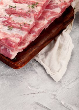 Gri arka planda çiğ pirzola. Gurme yemek pişirme konsepti. 