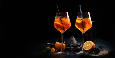 Aperol sprey kokteyli koyu arka planda servis edilir. Klasik içki menüsü konsepti. Ön görünüm