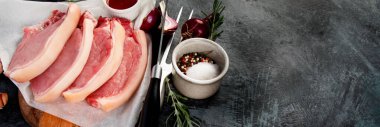 Koyu gri arka planda dilimlenmiş çiğ domuz eti. Organik gurme yemek konsepti. Üst görünüm, düz görünüm, kopyalama alanı, panorama