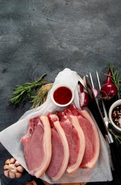 Koyu gri arka planda dilimlenmiş çiğ domuz eti. Organik gurme yemek konsepti. Üst görünüm, düz görünüm, kopyalama alanı