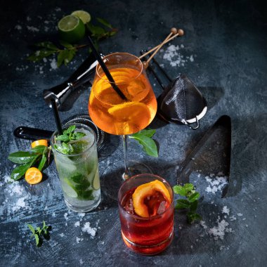 Koyu arkaplanda çeşitli kokteyller servis ediliyor. Klasik içki menüsü konsepti. 