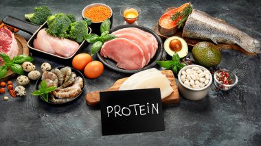 Koyu arkaplanda doğal protein kaynakları. Sağlıklı dengeli diyet kavramı. 