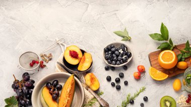 Açık gri masada meyve çeşitleri servis edilir. Yaz yemekleri konsepti. Üst görünüm, düz görünüm, kopyalama alanı