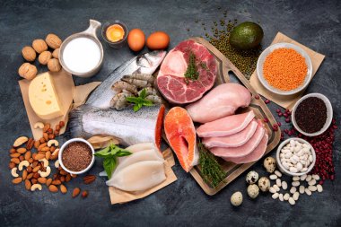 Koyu arkaplanda doğal protein kaynakları. Sağlıklı dengeli diyet kavramı. Üst görünüm, düz görünüm, kopyalama alanı