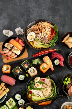 Gri arka planda Japon yemekleri ve atıştırmalıklar. Geleneksel gıda konsepti. Üst görünüm, düz görünüm, kopyalama alanı