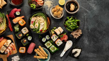 Gri arka planda Japon yemekleri ve atıştırmalıklar. Geleneksel gıda konsepti. Üst görünüm, düz görünüm, kopyalama alanı