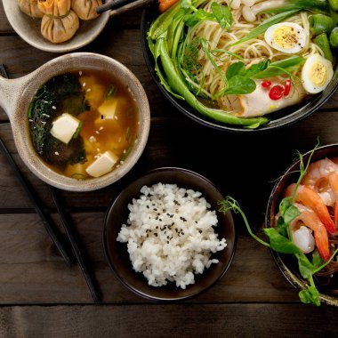 Ahşap arka planda Asya yemekleri ve atıştırmalıklar. Geleneksel gıda konsepti. Düz yatış, üst görünüm
