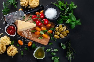 Koyu arka planda İtalyan yemeği ve atıştırmalıkları. Geleneksel gıda konsepti. Üst görünüm, düz görünüm kopyalama alanı