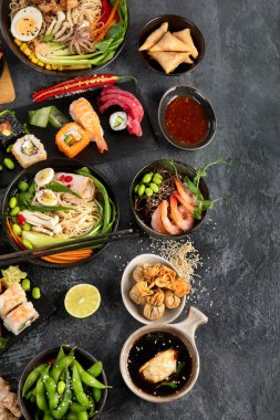 Gri arka planda Japon yemekleri ve atıştırmalıklar. Geleneksel gıda konsepti. Üst görünüm, düz görünüm, kopyalama alanı