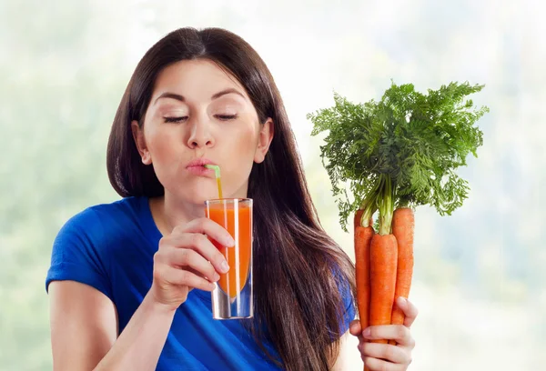 Chica bebiendo jugo de zanahoria — Foto de Stock