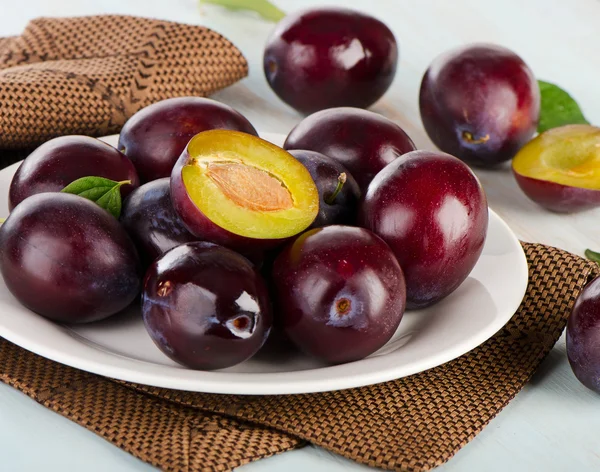 Ripe plums on white plate — Stock Photo, Image