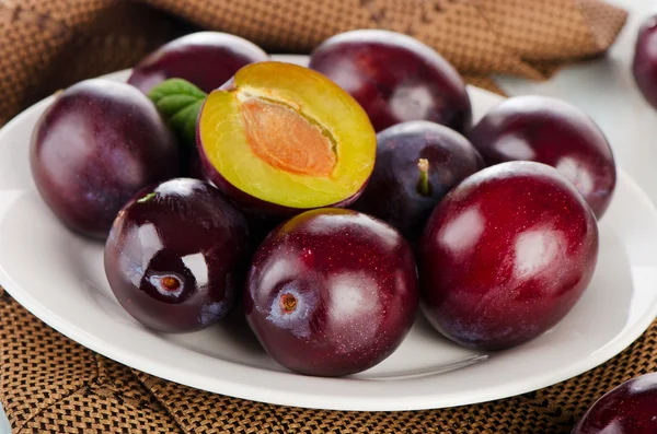 Fresh plums on white plate — Stock Photo, Image