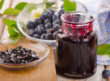 Ahşap bir masaya taze yaban mersini jam.