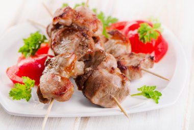 Beyaz tabakta sebze ile servis kebap