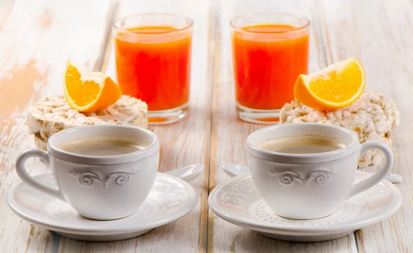 Zwei Kaffeetassen und Orangensaft — Stockfoto