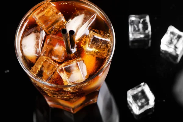 Un vaso lleno de cola con cubitos de hielo — Foto de Stock