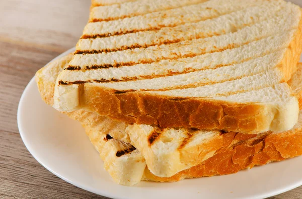 Rebanadas de pan tostado en plato blanco — Foto de Stock