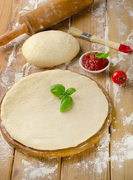 Pizza dough on a wooden board — Stock Photo, Image