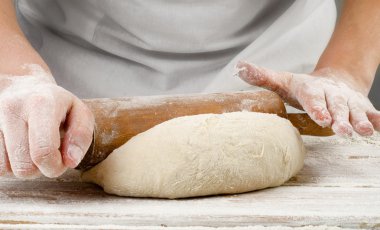 Hands preparing dough with rolling pin clipart