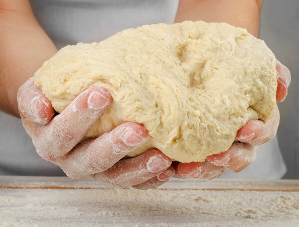 Hands holding dough
