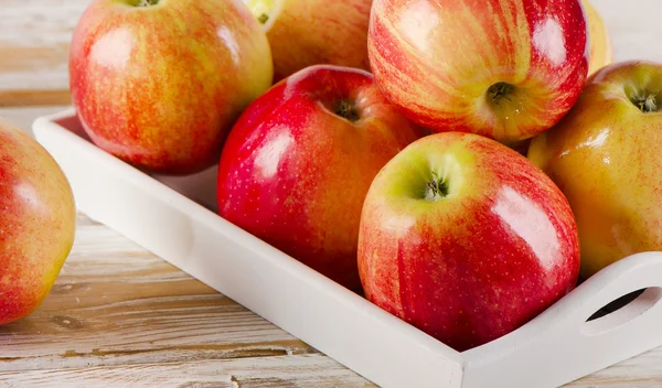 Fresh red apples  in white box on a wooden table — Stock Photo, Image