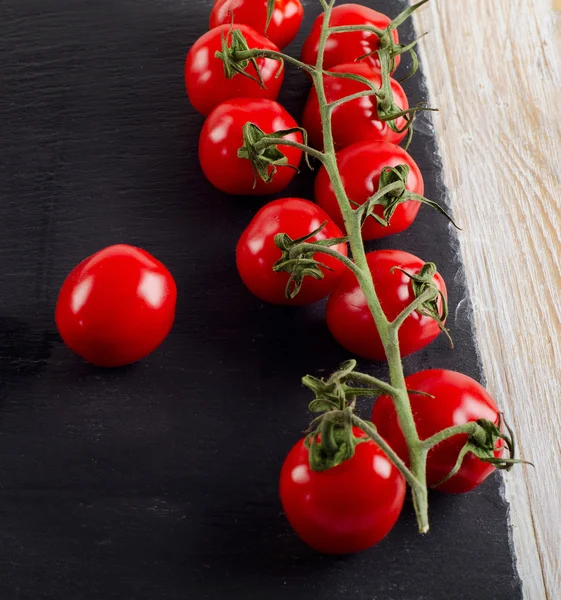 Čerstvá rajčata na černém pozadí — Stock fotografie