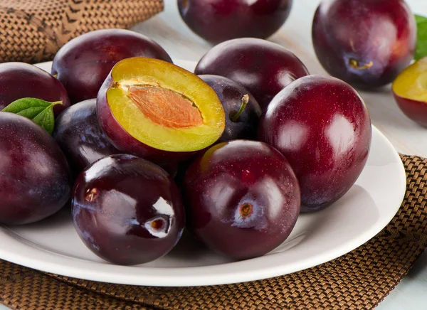 Prunes fraîches sur une assiette blanche — Photo