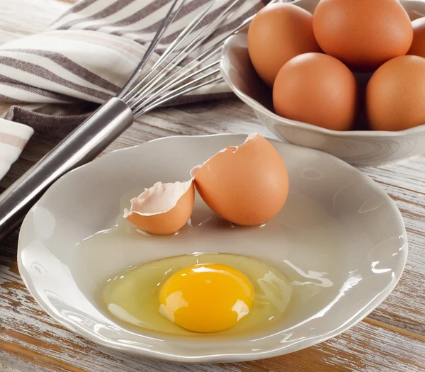 Ahşap arka plan üzerinde kırık çiğ yumurta — Stok fotoğraf