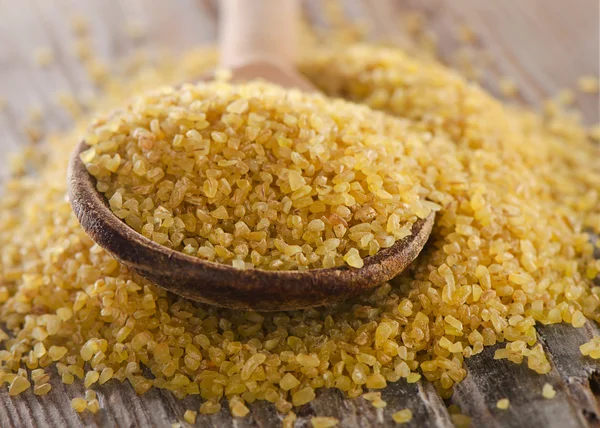 Bulgur in  wooden spoon — Stock Photo, Image