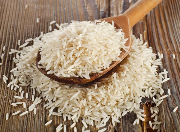 Uncooked rice in a wooden  spoon — Stock Photo, Image