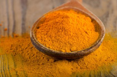 Bir tahta kaşık Curcuma toza