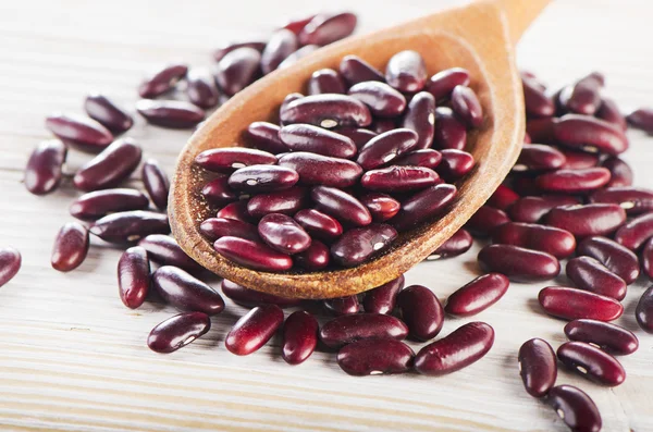 Haricots rouges dans une cuillère en bois . — Photo