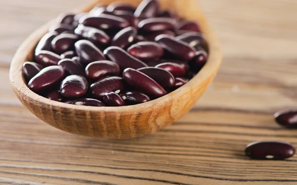 Haricots rouges dans une cuillère en bois . — Photo