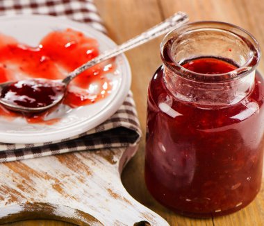 Ahşap arka plan üzerinde çilek reçeli.