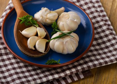 Bir kil plaka üzerinde taze organik sarımsak.